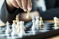 Close up shot hand of business woman moving golden chess to defeat a silver king chess on white and black chess board for Royalty Free Stock Photo