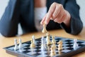 Close up shot hand of business woman moving golden chess to defeat a silver king chess on white and black chess board for Royalty Free Stock Photo