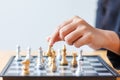 Close up shot hand of business woman moving golden chess to defeat a silver king chess on white and black chess board for Royalty Free Stock Photo