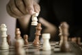 Close up shot hand of business woman playing the chess board to win by killing the king of opponent metaphor business competition