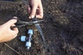 Close-up shot of hand of Caucasian elderly woman, age 63, cutting hose with scissors to connect triple fitting. A farmer installs Royalty Free Stock Photo