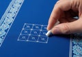 Hand drawing a tic tac toe grid with chalk on a blue surface isolated on white background Royalty Free Stock Photo