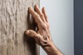 close-up shot of a hand gripping a climbing hold on an office wall Royalty Free Stock Photo