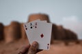 Close-up shot of a hand holding three aces in the background of the Derawar Fort in Pakistan Royalty Free Stock Photo