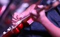 Close up shot of a hand strumming and playing a bright red electric guitar in a band Royalty Free Stock Photo