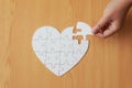 Close up shot hand of woman playing jigsaw puzzle on wooden tabl Royalty Free Stock Photo