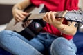 Close up shot of hand of young woman in casual clothes playing guitar Royalty Free Stock Photo