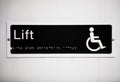 Close-up of handicapped elevator sign on wall