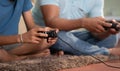Close up shot of hands of father with son playing video game by using joystick or game pad at home - concept of leisure Royalty Free Stock Photo