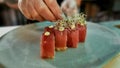 Close up shot of hands of professional sushi chef carefully adding final touch to his perfect tuna sushi set Royalty Free Stock Photo