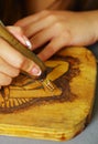 Close up shot of hands wood burning with pyrography pen