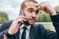 Close up shot of handsome young urban European businessman using mobile gadget outdoors Royalty Free Stock Photo