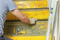 Close up shot of handyman build an interior staircase and covered with natural stone tiles