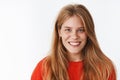 Close-up shot of happy charismatic good-looking young woman with chubby cheeks and white pleasant smile looking at