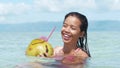 Close up shot of a happy woman drinking coconut in a relaxing vacation on island