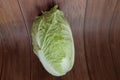 Close-up shot of a head of Chinese cabbage laying on wooden background, organic vegetables for cooking