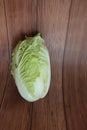 Close-up shot of a head of Chinese cabbage laying on wooden background, organic vegetables for cooking