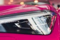 Close up shot headlight in luxury pink car background. Modern and expensive sport car concept. Royalty Free Stock Photo