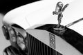 Close up shot of the hood ornament `Spirit of Ecstasy` and the logo of a vintage Rolls Royce car. Selective focus on the hood or Royalty Free Stock Photo