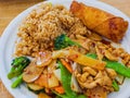 Close up shot of Hunan chicken with fried rice and egg roll