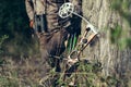 Close up shot of a hunter dressed in camouflage clothing holding a modern bow. Royalty Free Stock Photo