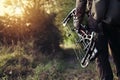 Close up shot of a hunter dressed in camouflage clothing holding a modern bow. Royalty Free Stock Photo