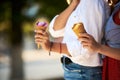 Close up shot of ice cream cones in hand of a woman standing with her friend. Two young women outdoors eating icecream Royalty Free Stock Photo