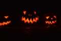 Close-up shot of illuminated carved pumpkins in a dark room