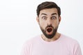 Close-up shot of impressed and shocked stunned caucasian guy with beard dropping jaw from amazement popping eyes at