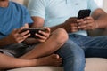 Close up shot of indian father and son hands busing using on there mobile phones while sitting on sofa at home - concept Royalty Free Stock Photo