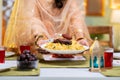 Close up shot of indian muslim woman hands placing chicken biryani plate on dining table at home - concept of Ramzan