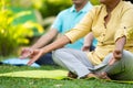 Close up shot of indian senior couple doing meditation or yoga while sitting on park - concept of wellness, healthy Royalty Free Stock Photo