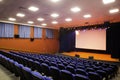 Close up shot of interior of cinema auditorium with lines of blue chairs. Horizontal shot