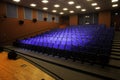 Close up shot of interior of cinema auditorium with lines of blue chairs. Horizontal shot