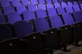 Close up shot of interior of cinema auditorium with lines of blue chairs. Horizontal shot