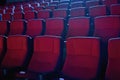 Close up shot of interior of cinema auditorium with lines of red chairs in front of a big screen Royalty Free Stock Photo