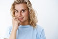 Close-up shot of intrigued cute european woman with blue eyes and short fair hair looking with desire and interest at Royalty Free Stock Photo