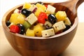 A close up shot of an isolated bowl of olivier salad on a table, showcasing its vibrant colors and textures