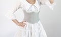 close-up shot of a lady dressed in a white dress with a wide grey leather belt or corset Royalty Free Stock Photo