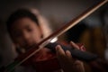 Close-up shot little girl playing violin orchestra instrumental with vintage tone and lighting effect dark and grain processed Royalty Free Stock Photo