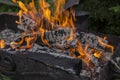 Close up shot of log pieces and fire wood, charcoal and ashes  burning in hot oranges flames in an old vintage brazier Royalty Free Stock Photo