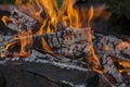 Close up shot of log pieces and fire wood, charcoal and ashes  burning in hot oranges flames in an old vintage brazier Royalty Free Stock Photo