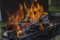 Close up shot of log pieces and fire wood, charcoal and ashes  burning in hot oranges flames in an old vintage brazier Royalty Free Stock Photo