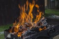 Close up shot of log pieces and fire wood, charcoal and ashes  burning in hot oranges flames in an old vintage brazier Royalty Free Stock Photo