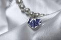 Love pendent on a satin cloth Royalty Free Stock Photo