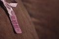 Close-up shot of luxury straps part of golden-purple floral lace women push up bra hanging on the brown cushion.