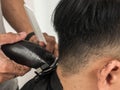 Close up shot of man getting trendy haircut. Male hairstylist serving client, making haircut using machine and comb. the concept