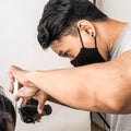 Close up shot of man getting trendy haircut. Male hairstylist serving client, making haircut using machine and comb. the concept