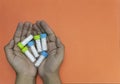 Close-up shot of a man hands holding bottle of homeopathic pills on apricot background. Medicine and treatment concept