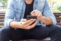 Close up shot of man hands using mobile while sitting on the ben Royalty Free Stock Photo